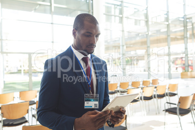 African-american businessman standing in conference room with tablet