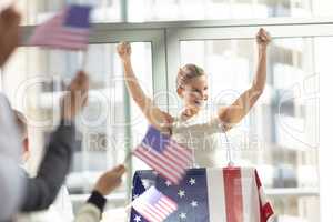 Young Caucasian businesswoman doing speech to business people in conference room during meeting