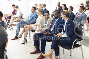 Young diverse executives sat in conference room, speaking