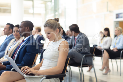 Young Caucasian female executive using laptop in conference room