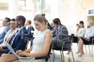 Young Caucasian female executive using laptop in conference room
