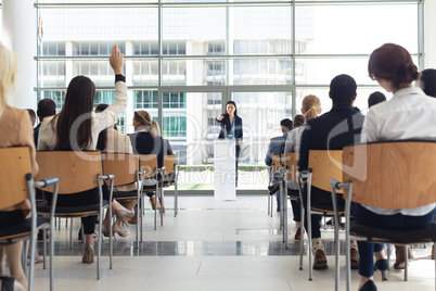 Young Asian female executive doing speech in conference room, answering questions