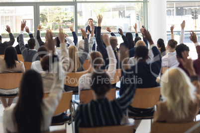 Mature Caucasian businesswoman doing speech and answering questions in conference room