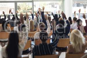 Mature Caucasian businesswoman doing speech and answering questions in conference room