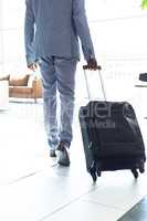 Young African-american male executive walking with suitcase