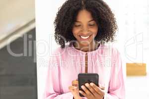 Young pretty African-american employee looking her phone
