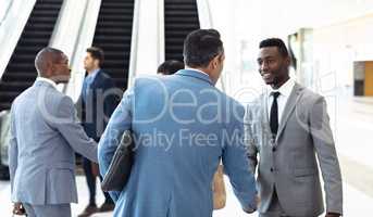 Diverse young executives meeting in front of escalator