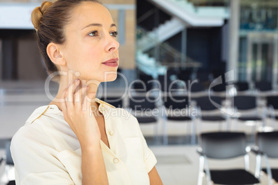 Caucasian female executive looking away while standing in empty conference room