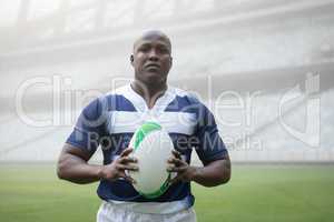 African american male rugby player holding a rugby ball in stadium