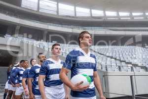 Diverse rugby players entering stadium in a row for match