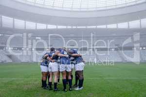 Group of male rugby players forming huddles in the morning