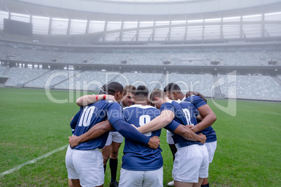 Group of male rugby players forming huddles in the morning