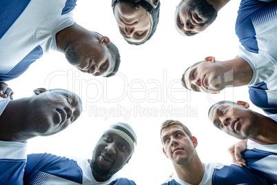 Group of Male rugby players forming huddles in stadium