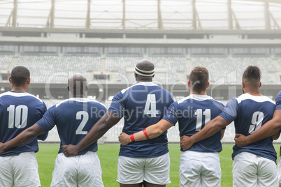 Group of diverse male rugby players taking pledge together in stadium