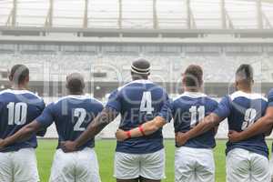 Group of diverse male rugby players taking pledge together in stadium