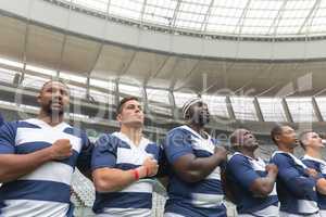 Group of diverse male rugby players taking pledge together in stadium