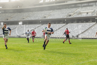 Group of diverse male rugby players playing rugby in stadium