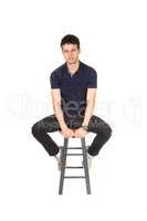 Handsome tall young man sitting on chair in the studio