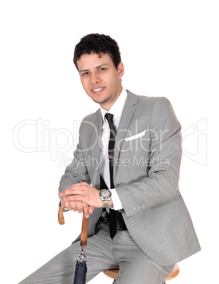 Young handsome man sitting with a umbrella and smiling