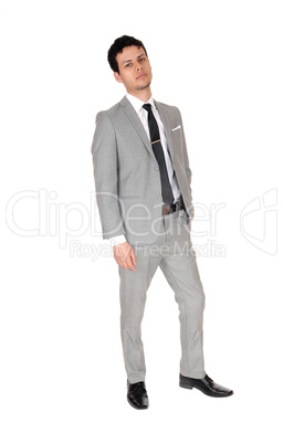 Young business man standing relaxed in a gray suit