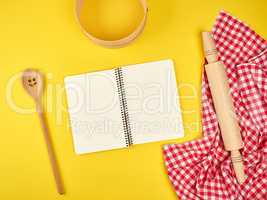 blank open notebook and wooden kitchen accessories