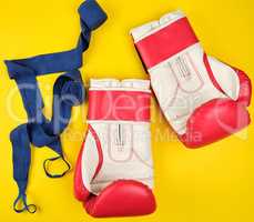 pair of red leather boxing gloves and blue textile bandage,