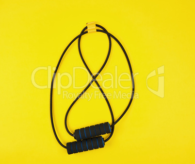 black trainer hand expander on a yellow background