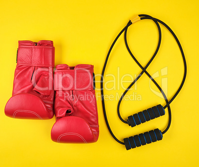 pair of red leather boxing gloves and black trainer hand expande