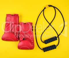 pair of red leather boxing gloves and black trainer hand expande