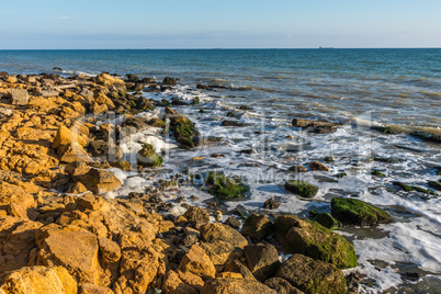 Sea foam and stones on the shore