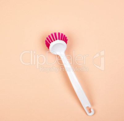 kitchen brush with white plastic handle on a beige background