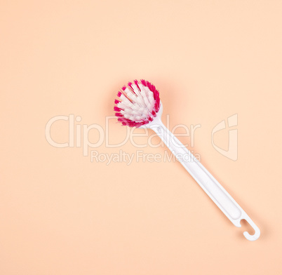 kitchen brush with white plastic handle on a beige background