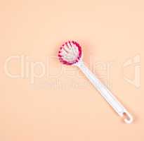 kitchen brush with white plastic handle on a beige background