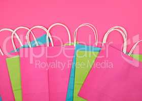 rectangular multi-colored paper shopping bags with white handles