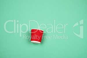 red paper cup with corrugated edges for hot drinks on a green ba