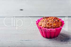 Oatmeal muffin in pink bakeware.