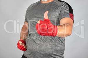 sportsman's hands wrapped in red elastic sports bandage show a l