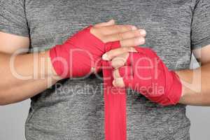 sportsman?s hands wrapped in a red elastic sports bandage