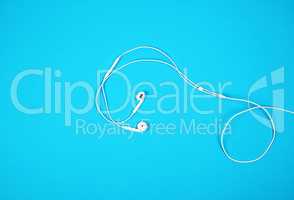white earphones with a cable on a blue background