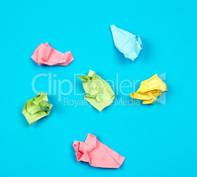 crumpled bright multi-colored paper on a blue background