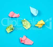 crumpled bright multi-colored paper on a blue background