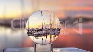 Crystal  ball of Sunrise over a quiet harbor in old Naples, Flor