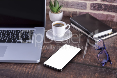 Laptop notebook with blank screen and cup of coffee and notepad
