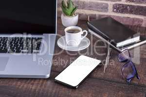 Laptop notebook with blank screen and cup of coffee and notepad