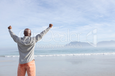 Man with arms raised at the beach