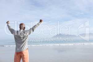 Man with arms raised at the beach
