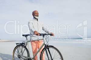 Man holding a bicycle on the beach