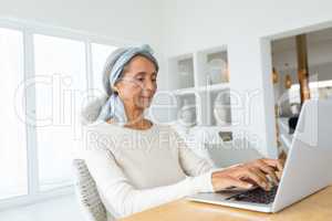 Woman using a white laptop on a table.