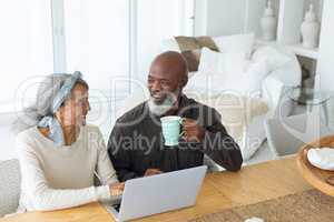 Couple using white laptop on table while man holds a cup