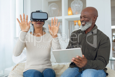Couple using digital devices while sitting inside a room